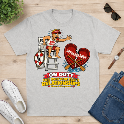 A light gray crewneck t-shirt with a cartoon graphic of a lifeguard on duty, displayed in a flat-lay arrangement on a light wood background with white sneakers, blue jeans, sunglasses, and a watch.