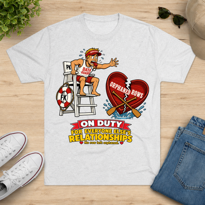 A white graphic t-shirt laid flat on a light wood surface, surrounded by lifestyle props including white sneakers, a pair of jeans, sunglasses, and a hat. The t-shirt features a cartoon graphic of a lifeguard on duty with a broken heart and the text 'ON DUTY FOR EVERYONE ELSE'S RELATIONSHIPS'.
